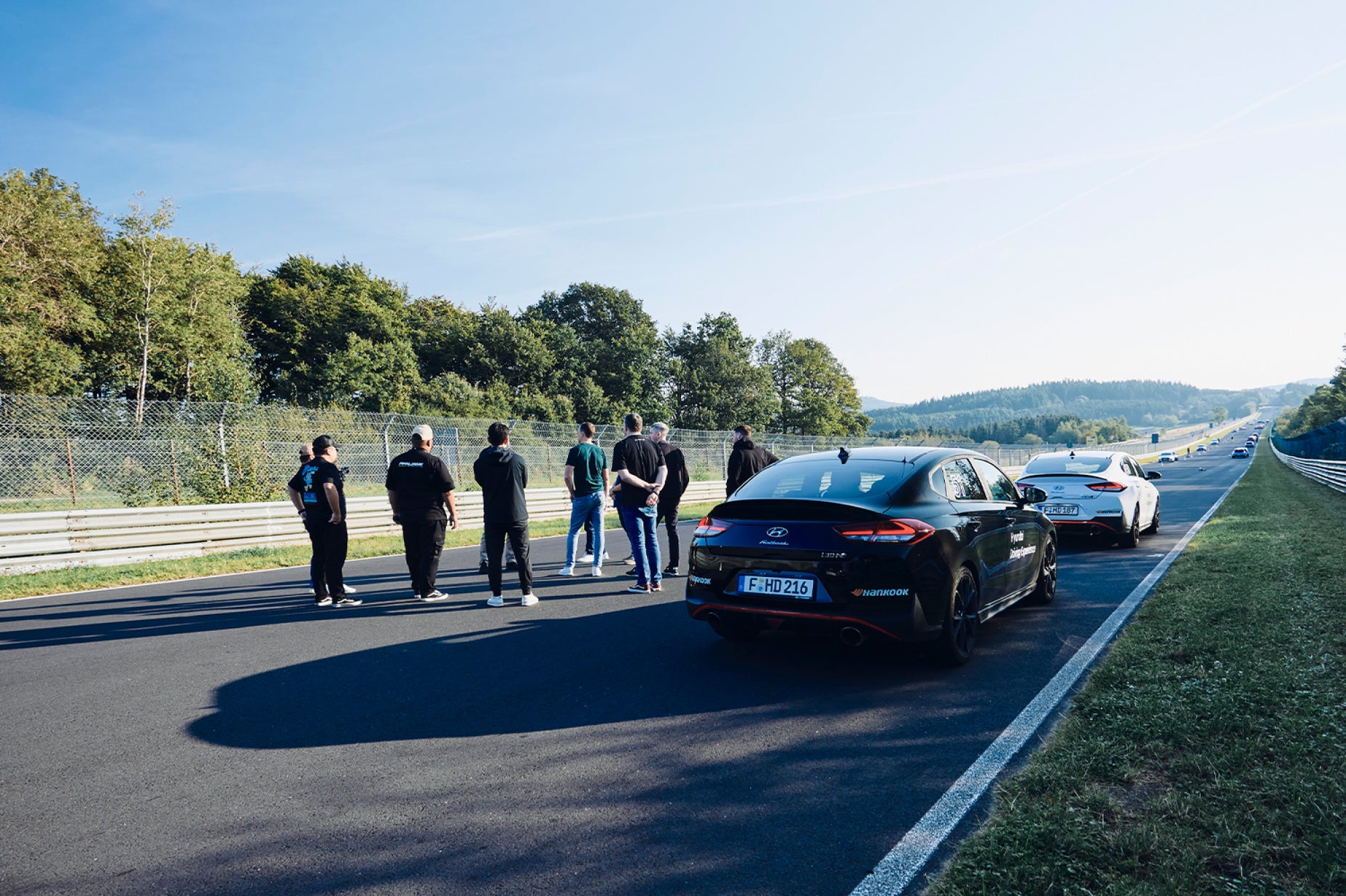 People on racetrack receiving instructions at a Hyundai tack experience