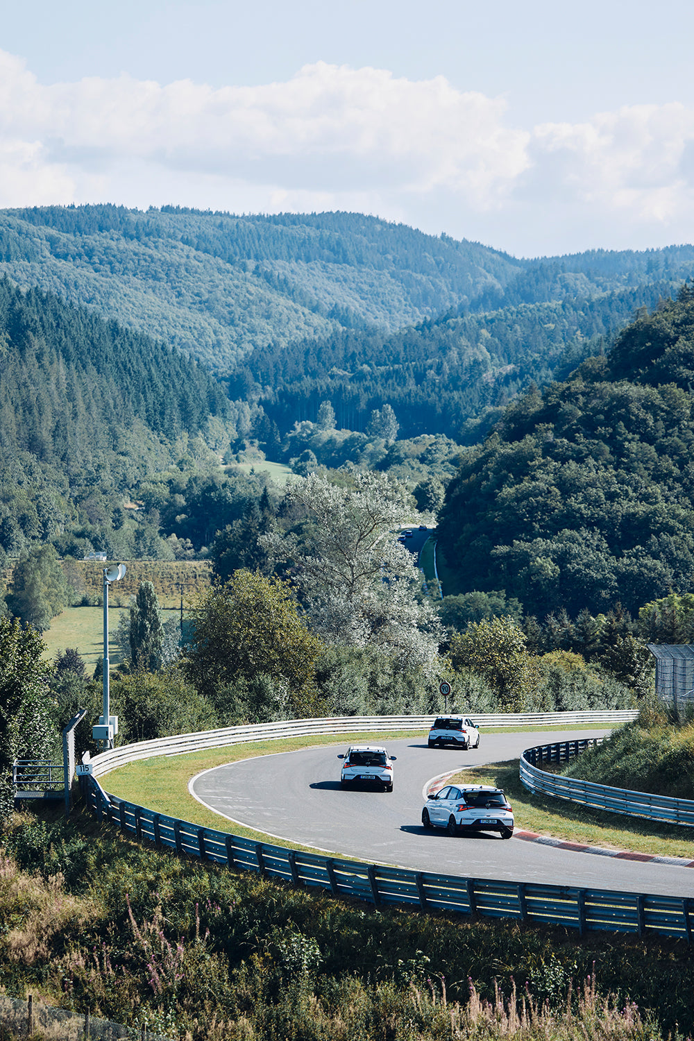 Hyundai i30 N cars taking a corner on a racetrack
