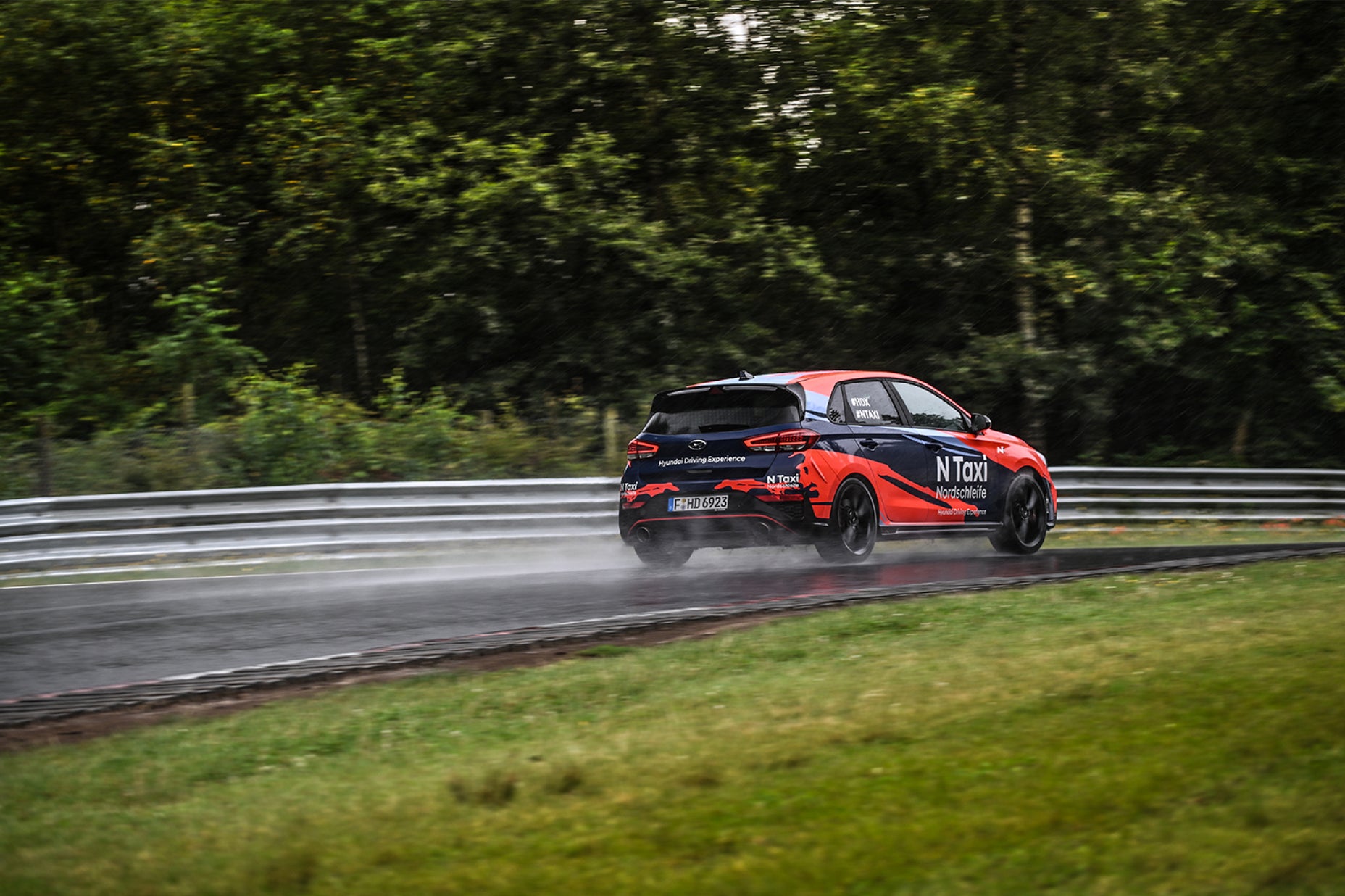 Hyundai N Taxi car on the Nordschleife track in wet conditions
